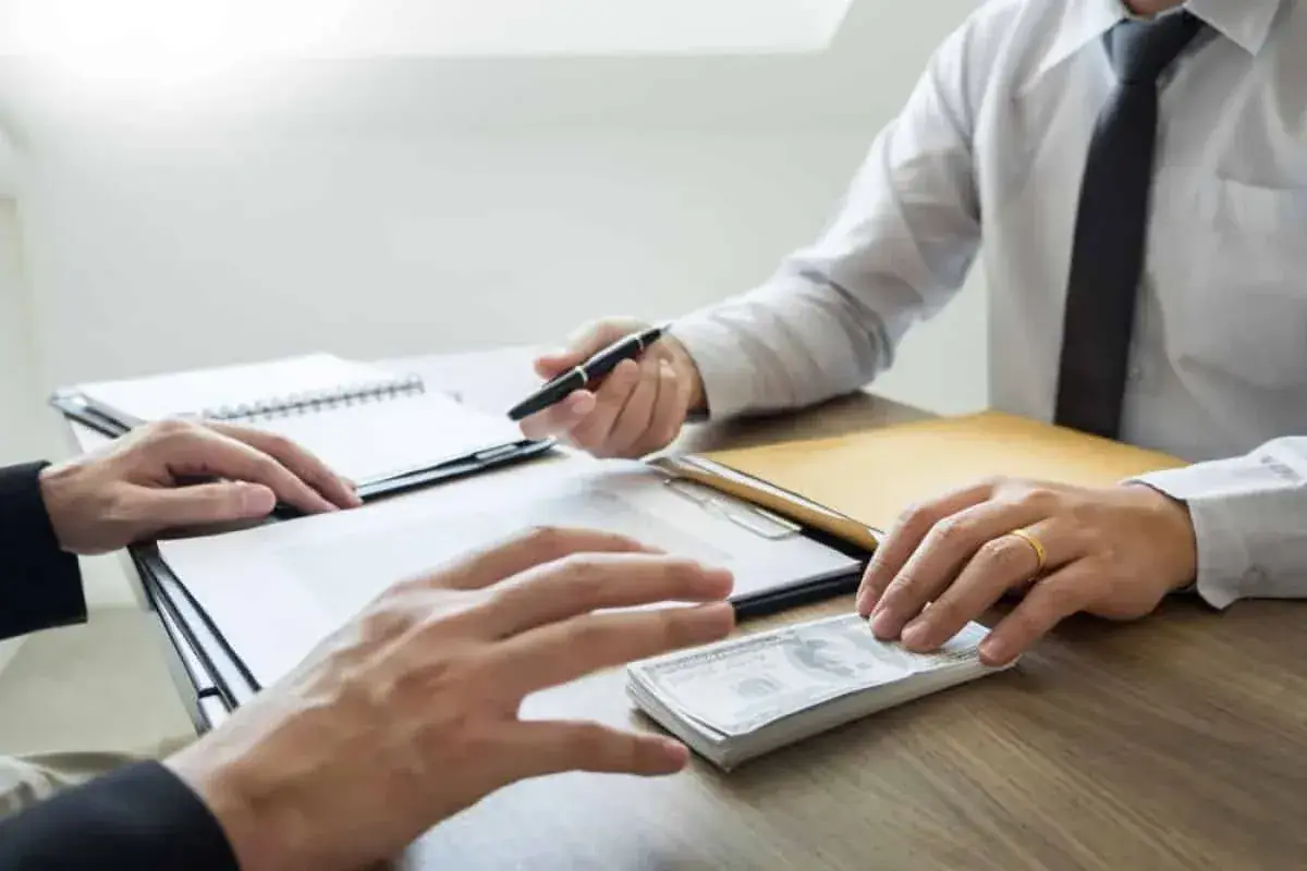 Client counting bail money at a desk with paperwork
