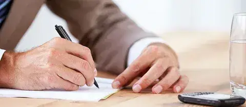 Person taking notes during a phone consultation