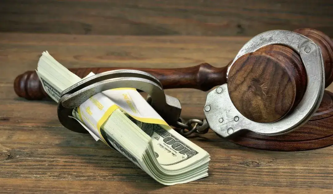 Cash, gavel and handcuffs arranged on a desk