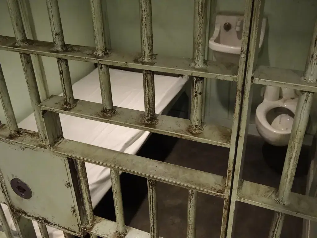 Empty jail cell with steel bars in a detention facility